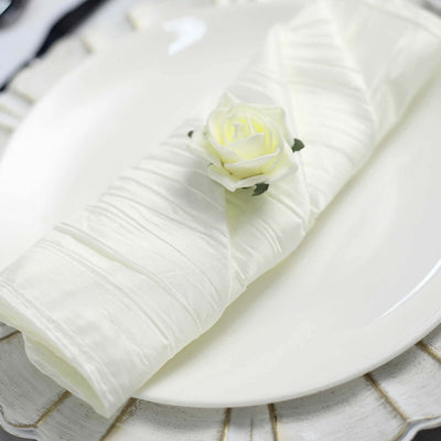 Elegant white napkin with a rose on a decorative plate.