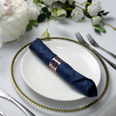 Navy blue napkin elegantly rolled on a white plate with a decorative gold rim.