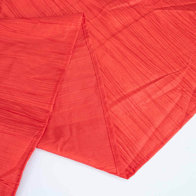 Red textured fabric draped elegantly on a flat surface.