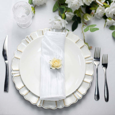Elegant table setting with white plate, napkin, and rose decoration.