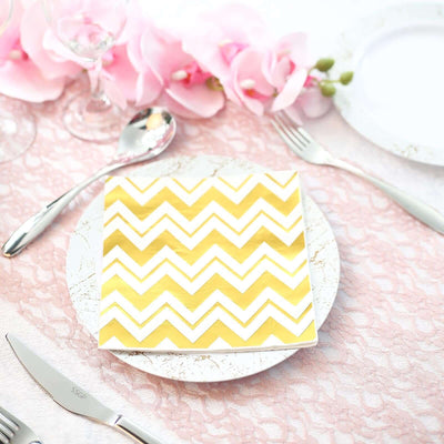 Gold chevron paper napkin on a decorative plate with pink flowers