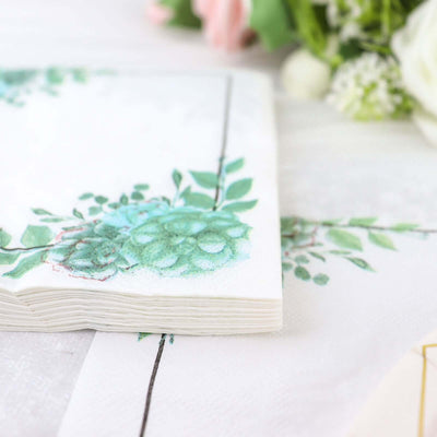 Decorative napkins with floral design and green succulents on a white background.