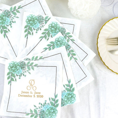 Personalized floral napkins with gold monogram for wedding decor.