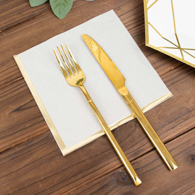 Gold cutlery set on a napkin, styled for elegant dining.