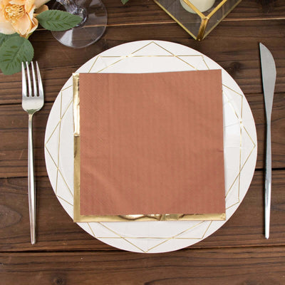 Elegant rose gold napkin on a decorative plate set for dining.
