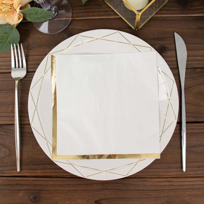 Elegant gold-trimmed plate with napkin on a rustic wooden table setting.
