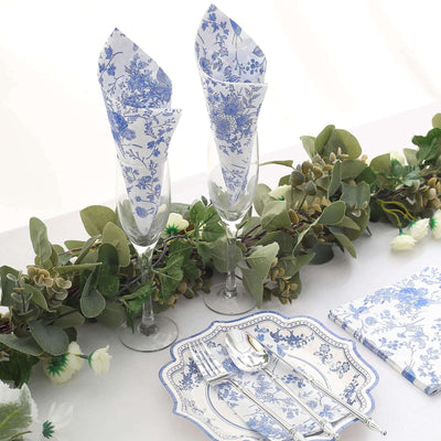 Elegant blue floral napkins with champagne flutes and tableware for a sophisticated table setting.