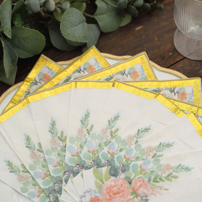 Floral napkins with gold trim arranged on a decorative plate.