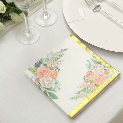 Floral printed napkin with gold trim on a dining table setting.
