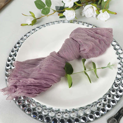 Soft mauve scarf elegantly tied on a plate with greenery accents.