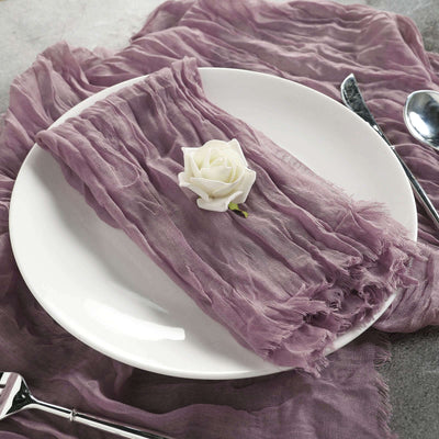 Purple linen napkin on a white plate with a rose decoration.