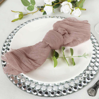 Elegant mauve scarf tied on a plate with greenery, perfect for table settings.