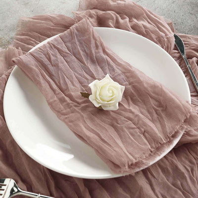 Textured mauve napkin with a white rose on a plate.