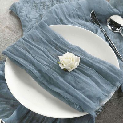 Elegant blue textured napkin with a white rose on a plate.
