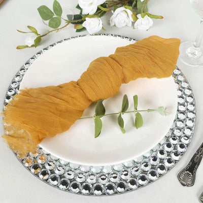 Mustard yellow table napkin elegantly wrapped on a decorative plate with greenery.