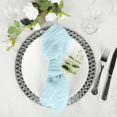 Elegant table setting with a light blue napkin and decorative plate.
