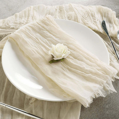 Elegant cream-colored linen napkin with a white rose on a plate.