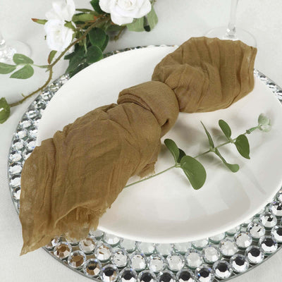 Brown linen napkin tied elegantly on a decorative plate with greenery.