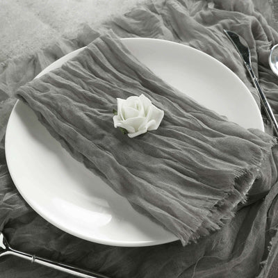 Gray textured napkin on a white plate with a decorative rose.