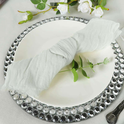Elegant light gray napkin with greenery on a decorative plate.