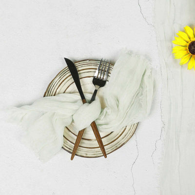Elegant plate set with cutlery and green linen, accented by a sunflower.