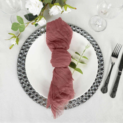 Rustic pink linen napkin elegantly styled on a decorative plate with greenery