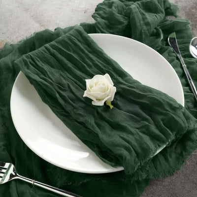 Green textured napkin on a plate with a white rose decoration.