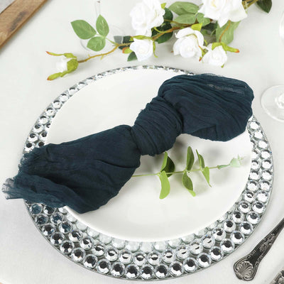 Navy blue linen napkin elegantly tied on a decorative plate with greenery.