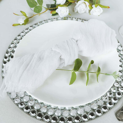 White linen napkin elegantly styled on a decorative plate with greenery accent.