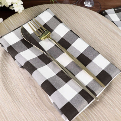 Black and white checkered napkin with fork on a wooden table.