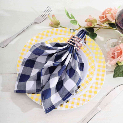 Navy and white checkered napkin with gold rings on a yellow and white plate