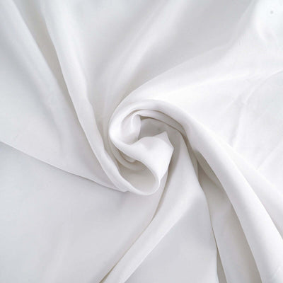 Soft white fabric draped in gentle folds, showcasing smooth texture.