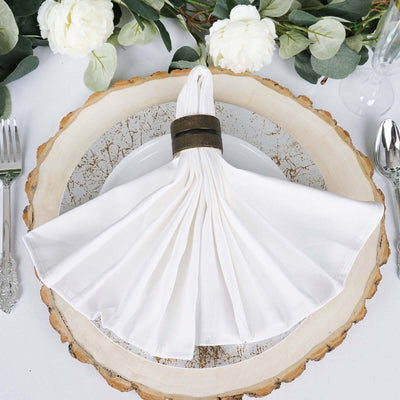 Elegant white napkin with a decorative ring on a rustic plate.