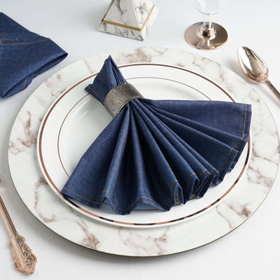 Denim napkin elegantly folded on a marble dining plate.