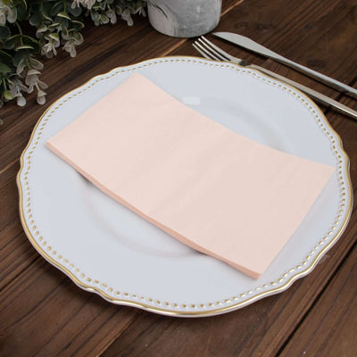 Peach napkin on an elegant white plate with gold trim.