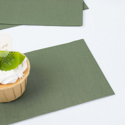 Cupcake with green topping on textured paper background.