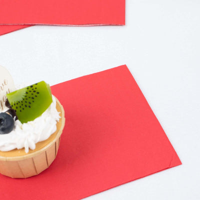 Fruit-topped cupcake on a red napkin, showcasing vibrant colors and textures.