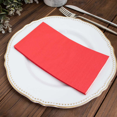 Red napkin neatly placed on an elegant plate.