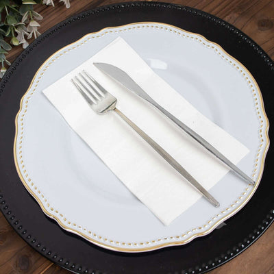 Elegant silver fork and knife on a white plate with a napkin.