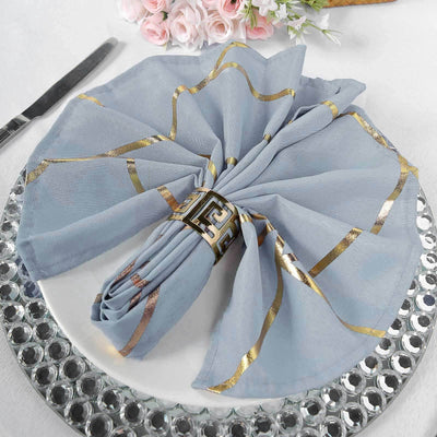 Elegant blue napkin with gold accents, styled on a decorative plate.