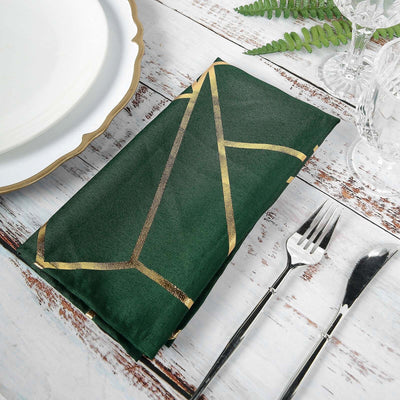 Green napkin with gold geometric design on rustic table setting.