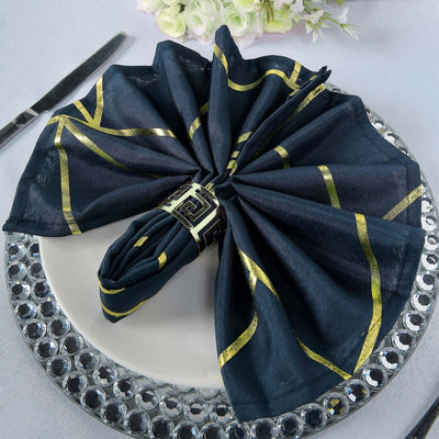 Elegant black napkin with gold accents, beautifully arranged on a decorative plate.