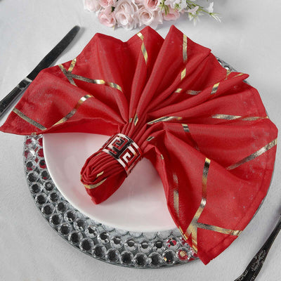 Red decorative napkin with gold accents, elegantly arranged on a plate.