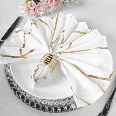 Elegant white napkin with gold accents, beautifully arranged on a decorative plate.