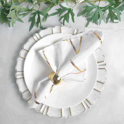 Elegant white napkin with gold accents, styled on a decorative plate.