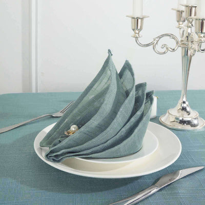 Elegant teal napkins arranged on a white plate for a stylish table setting.
