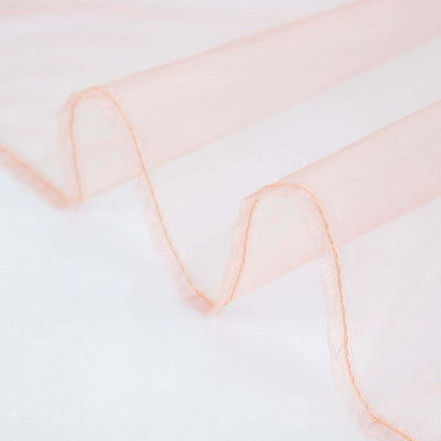 Peach sheer fabric draped elegantly on a white background.
