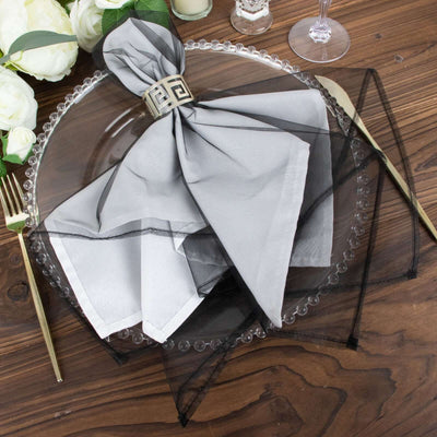 Elegant gray napkin with black overlay on a decorative plate.