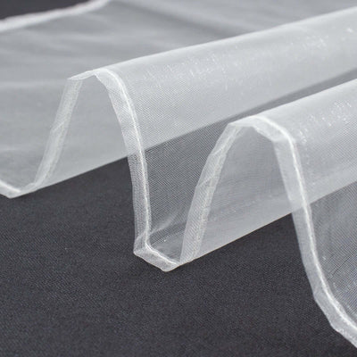 Sheer white fabric draped elegantly on a dark surface.