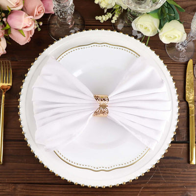 Elegant white napkin elegantly folded on a decorative plate with gold accents.